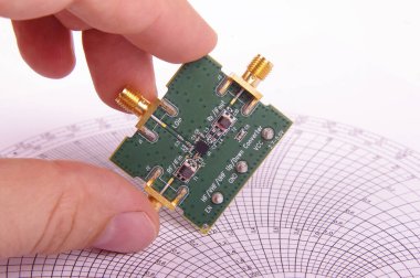 Radyo frekans mühendisi, Smith grafiğinin önündeki mikrodalga karıştırıcı yazdırılmış devre kartı Pcb 'yi denetle