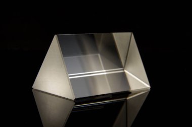 Siyah yansıtıcı arka planda izole edilmiş bilimsel deneyler için üçgen optik prizma