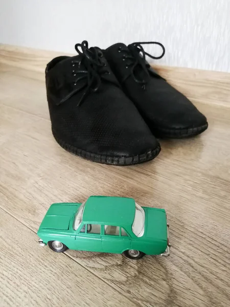 黒の男性の靴と比較して車のモデルのおもちゃ — ストック写真