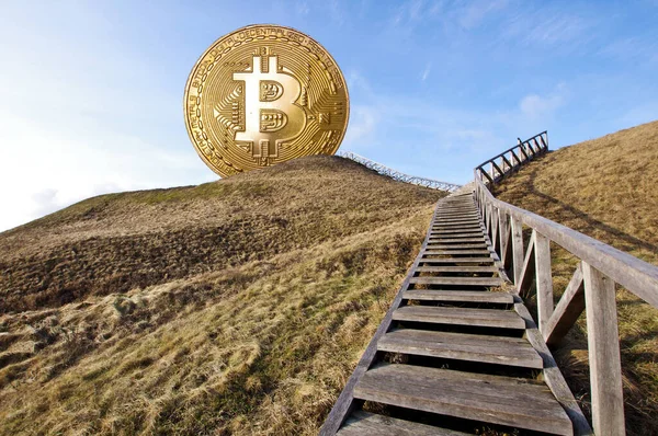 Tepenin tepesinde ve ona doğru merdivenlerde sembolik Bitcoin var.