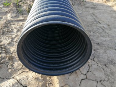 Siyah PVC plastik drenaj borusu delinmiş. Su kanalizasyonu için.