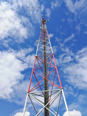 Ana istasyon ve mavi bulutlu gökyüzünün önündeki tekrarlayıcı kule (Global System for Mobile communication)