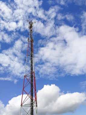Ana istasyon ve mavi bulutlu gökyüzünün önündeki tekrarlayıcı kule (Global System for Mobile communication)