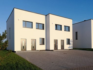 Akşam ışıklarıyla modern, yeni bir beyaz ev. Emlak kavramı