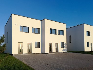 Akşam ışıklarıyla modern, yeni bir beyaz ev. Emlak kavramı