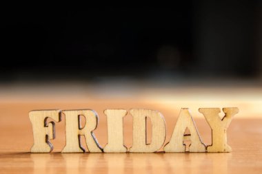 Kelime 'Cuma' ahşap harflerin yaptı. Tablo ve koyu siyah arka plan üzerinde ahşap yazıt