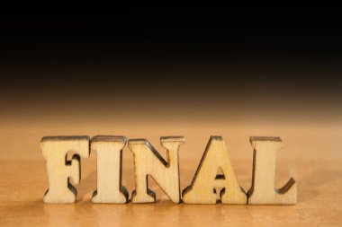 Kelime 'final' ahşap harflerin yapılmış. Tablo ve koyu siyah arka plan üzerinde ahşap yazıt