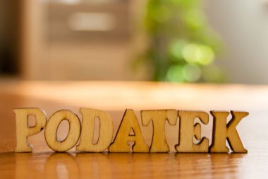 Lehçe kelime vergi 'ahşap harflerin yapılan podatek'. tablo üzerinde ahşap yazıt