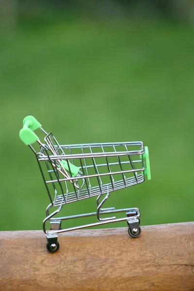 Mini Wózek Zakupy Stole Który Świeci Słońcu Symbolizujące Marketing Zakupy — Zdjęcie stockowe