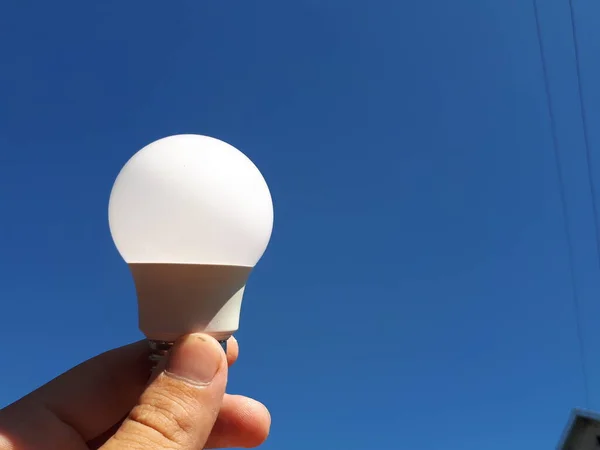 Bombilla Led Sobre Fondo Cielo Azul Mano Humana Concepto Electricidad —  Fotos de Stock