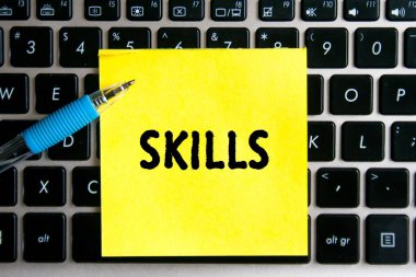 Bilgisayar klavyesinin arka planında sarı bir etiket kağıdına 