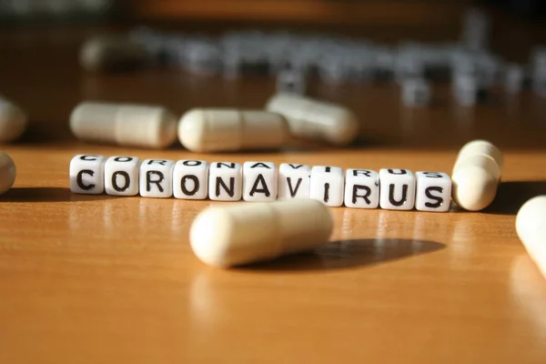 Slovo Koronavirus Dřevěném Pozadí Stolu Tabletami Pilulkami Porcelán Ncov Infekce — Stock fotografie