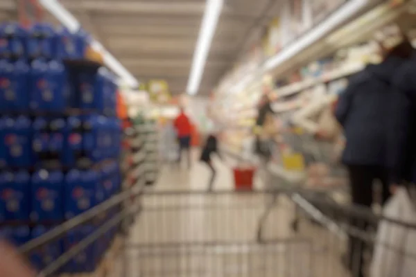 Blurred abstact background of shopping cart in supermarket . Blurry view inside department store with shopping trolley. Shopping cart in supermart aisle and shelves with blurred background.