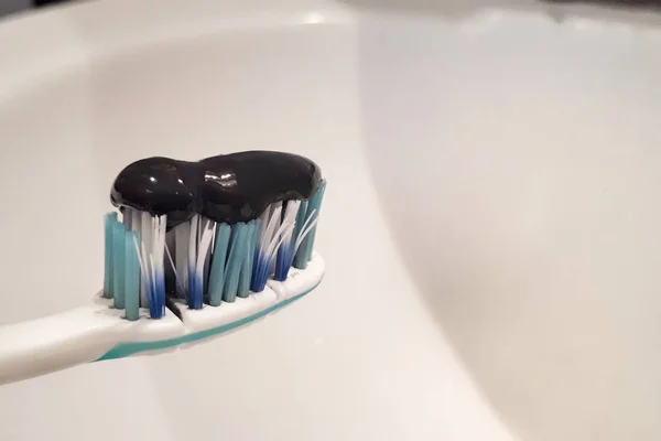 Schwarze Zahnpasta Mit Aktivkohle Und Schwarze Zahnbürste Auf Weißem Hintergrund — Stockfoto