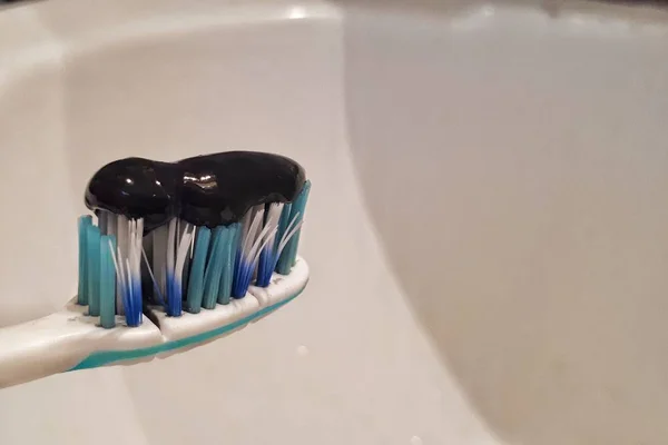 Schwarze Zahnpasta Mit Aktivkohle Und Schwarze Zahnbürste Auf Weißem Hintergrund — Stockfoto