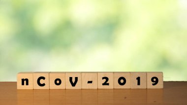 Yeşil arka planda tahta küplere yazılmış nCoV 2019 Coronavirus. Bokeh doğası yeşil renkli Coronavirus arkaplanı.