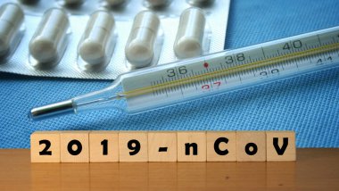 Coronavirus covid-19 ve arka planda termometre. Üzerinde 2019-NCov yazan tahta bloklar. Koronavirüs karantinası kavramı.