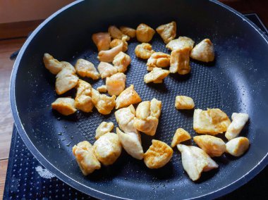 Tavada tavuk eti parçaları. Tüketime hazır baharatlı et..