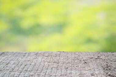 Boş ahşap masa. Sabah arka planda bahçe ve evden soyut yeşil..
