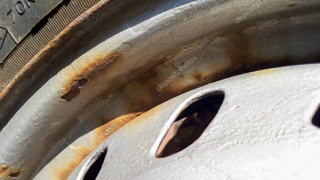 Closeup of rust on rims and screws from a car wheel