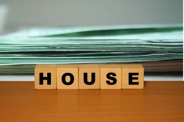 Küp bloklardaki ahşap bir masada nakit avro ve dolar geçmişi olan bir ev mesajı. İpotek kavramı