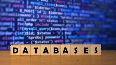 Küp bloklardaki ahşap bir masadaki veri tabanı mesaj sözcüğü. Arka grubunda mavi kod var.