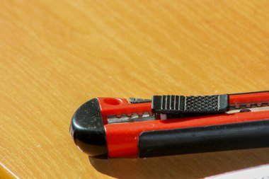 Ahşap masada kırmızı bıçak makası..