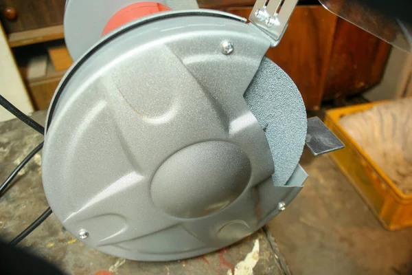 Close-up of abrasive disc on bench grinder machin