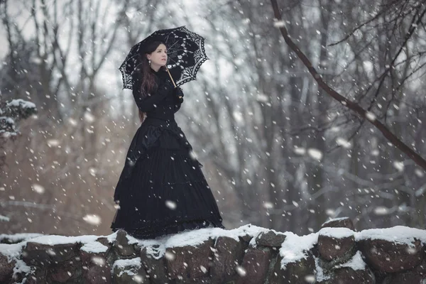 Mujer en vestido negro victoriano en el parque de invierno — Foto de Stock