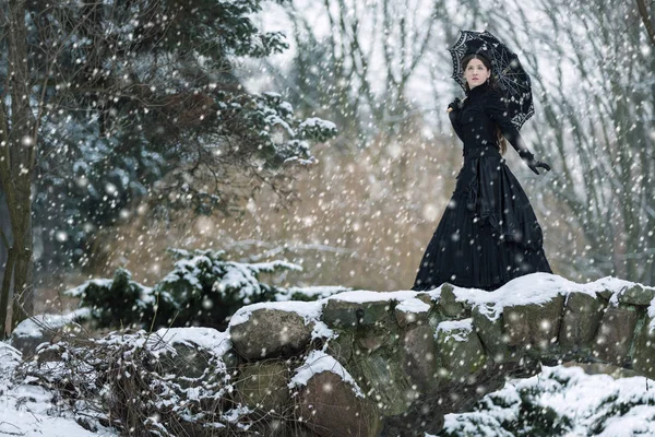Frau im schwarzen viktorianischen Kleid im Winterpark — Stockfoto
