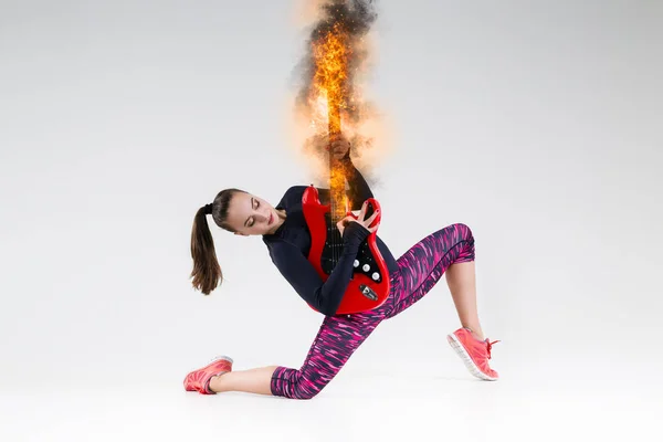 Mulher com uma guitarra em chamas no estúdio — Fotografia de Stock