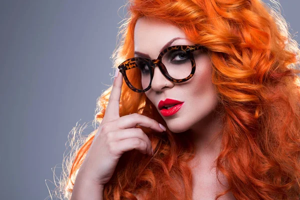 Portrait of a beautiful red-haired woman in glasses Stock Image