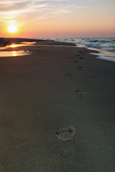 Voetafdrukken op het strand bij zonsondergang — Stockfoto