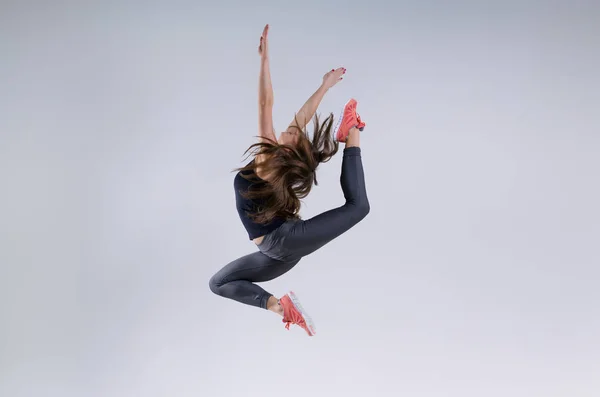 Девушка в прыжке на сером фоне — стоковое фото