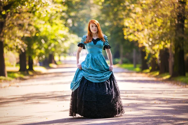 Mulher de cabelos vermelhos em vestido vitoriano com parque de outono — Fotografia de Stock