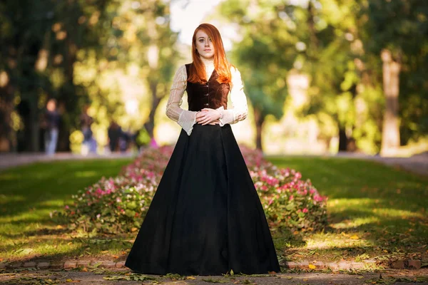 Mujer pelirroja en traje victoriano con parque de otoño — Foto de Stock