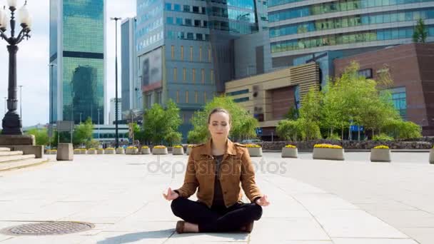 Женщина медитирует на оживленном тротуаре в центре города — стоковое видео
