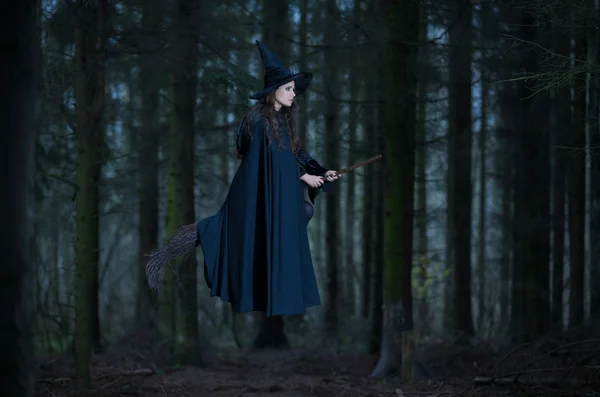 Sorcière volant sur un balai dans la forêt — Photo