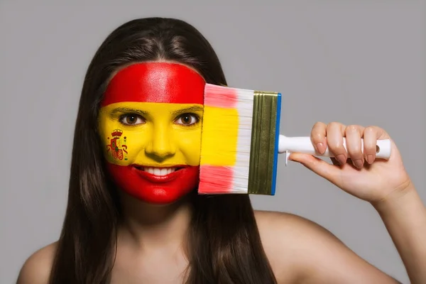 Het gezicht van een vrouw in de nationale kleuren van Spanje — Stockfoto