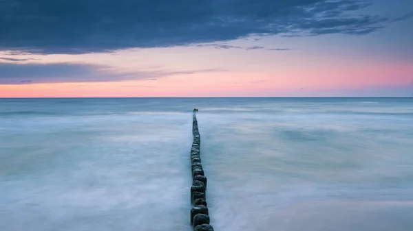 Wooden breakwater on the Baltic sea at dusk — Stock Photo, Image