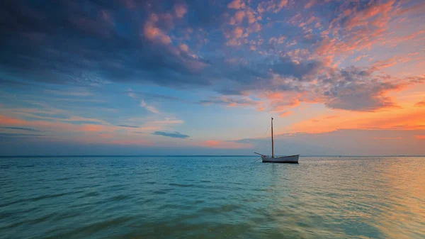 Osamělá loď na břehu Baltského moře při západu slunce — Stock fotografie