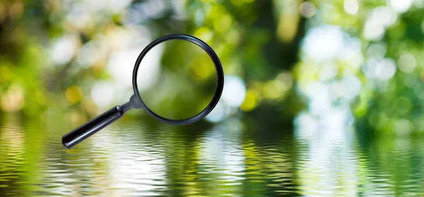 Magnifying glass on green background closeup — Stock Photo, Image