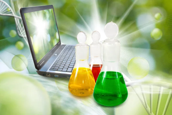 Frascos com líquido e laptop em close de laboratório — Fotografia de Stock
