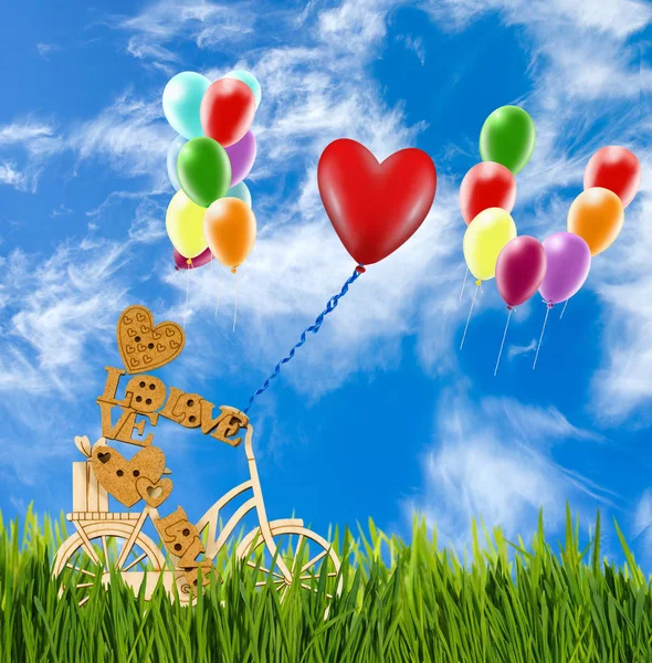 Kép dekoratív kis ember és a léggömbök az ég ellen kerékpár. — Stock Fotó
