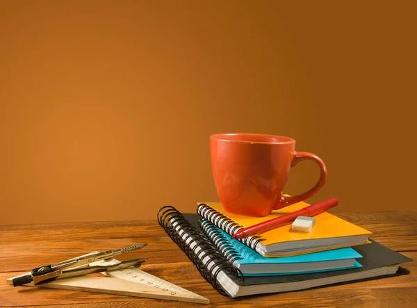 Notizbuch. Bleistift, rote Tasse mit Getränk auf einem Holztisch — Stockfoto