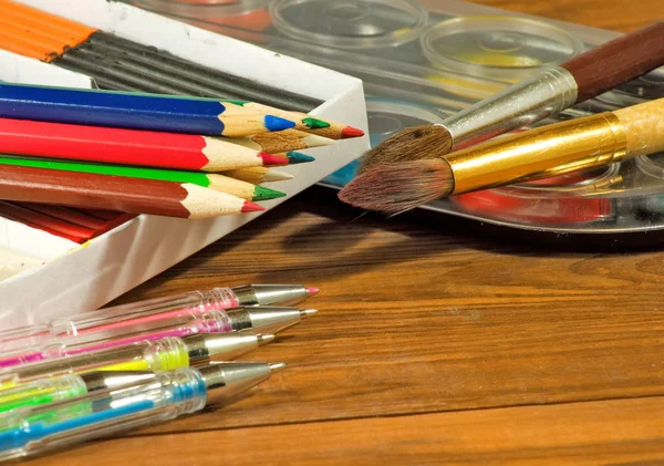 Crayons, stylos, peinture, argile sur la table — Photo