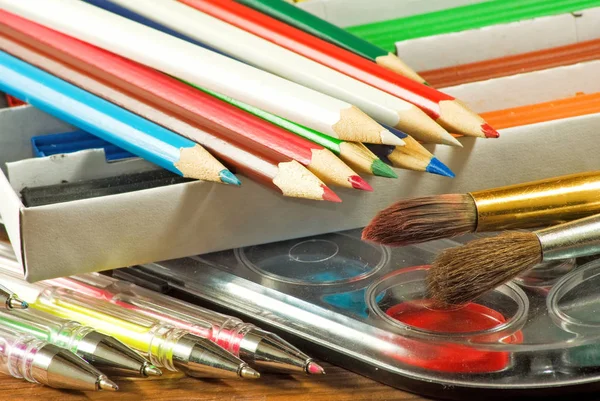 Олівці, ручки, фарба, глина на столі — стокове фото