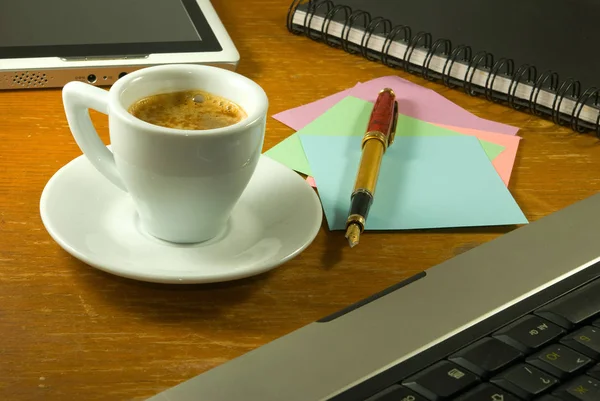 Чашка кави, канцтоварів, клавіатури і планшета на столі крупним планом — стокове фото