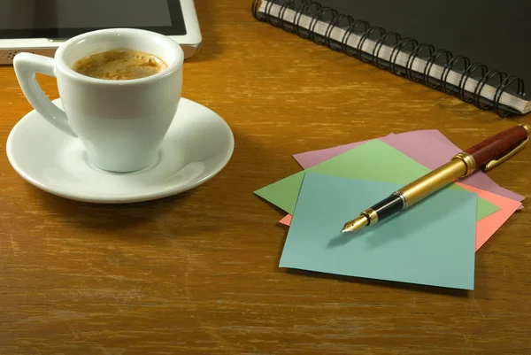 Чашка кофе, канцелярские принадлежности, клавиатура и планшет на столе крупным планом — стоковое фото