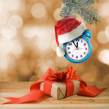 Noel ağacı süslemesi olarak alarm saati ve kırmızı Noel şapkası resmi